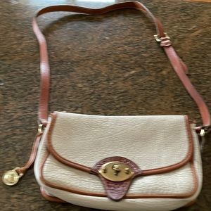 Dooney and Bourke shoulder bag. Off white with saddle brown trimming.